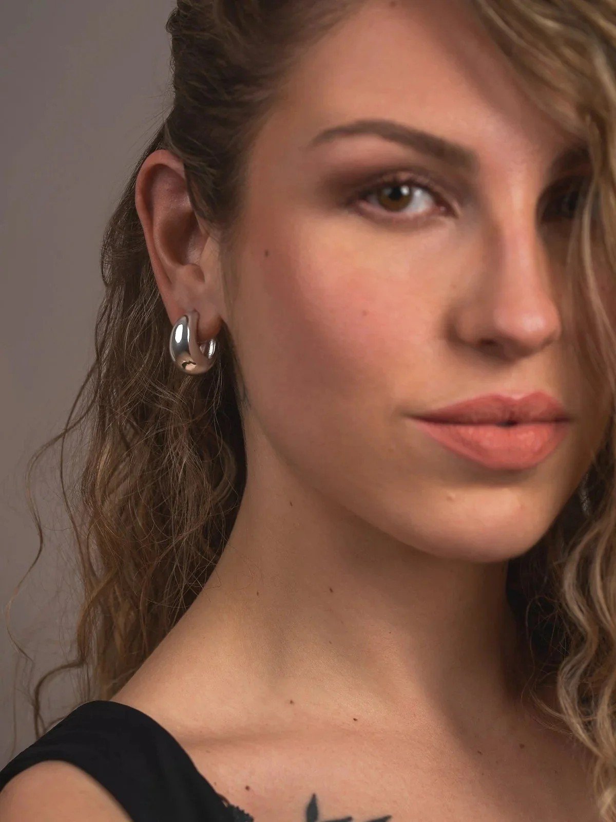 Elise hoop worn by model — sculptural softness in silver tone