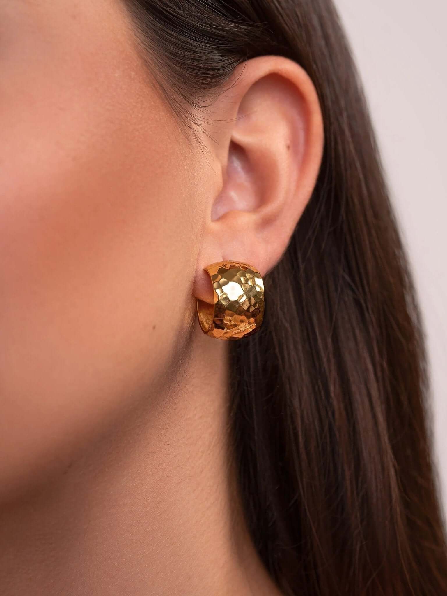 Model wearing 24K gold-plated wide hoop earrings, showcasing their rich golden shine.