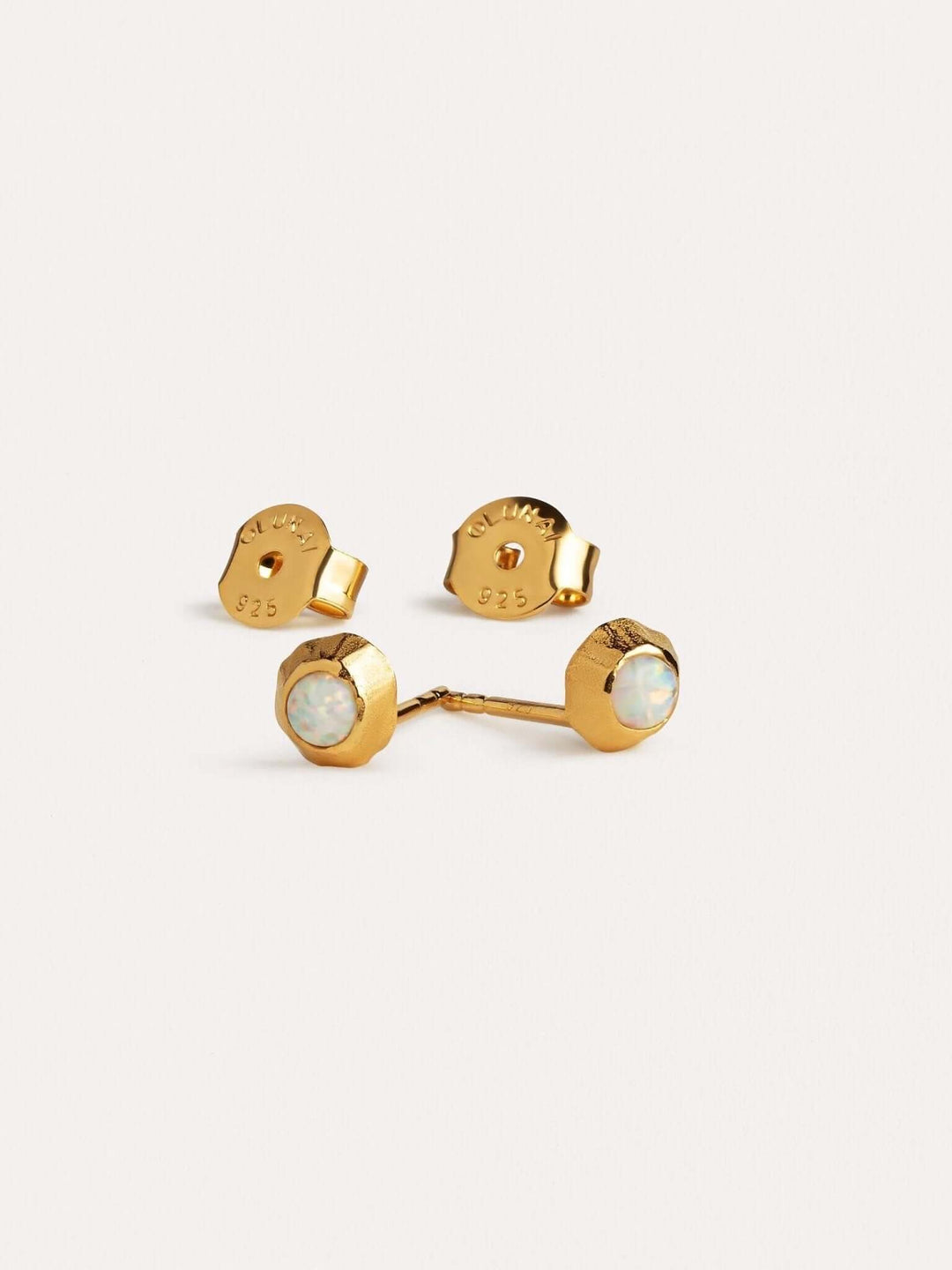 Gold gemstone stud earrings featuring warm-toned stones on a soft backdrop.