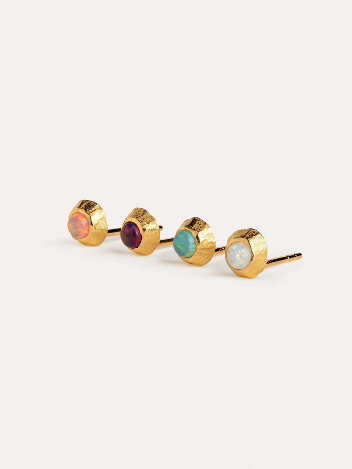 Gold stud earrings with four colorful gemstones: green, red, blue, and yellow.