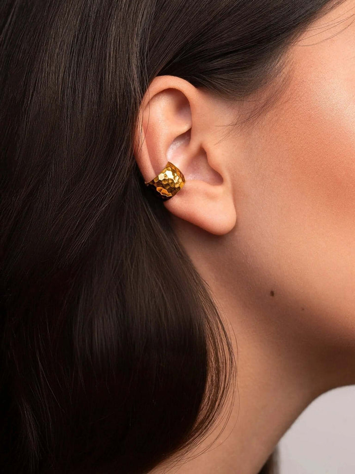 Close-up of the handcrafted gold conch cuff earring with hammered finish and elegant texture.