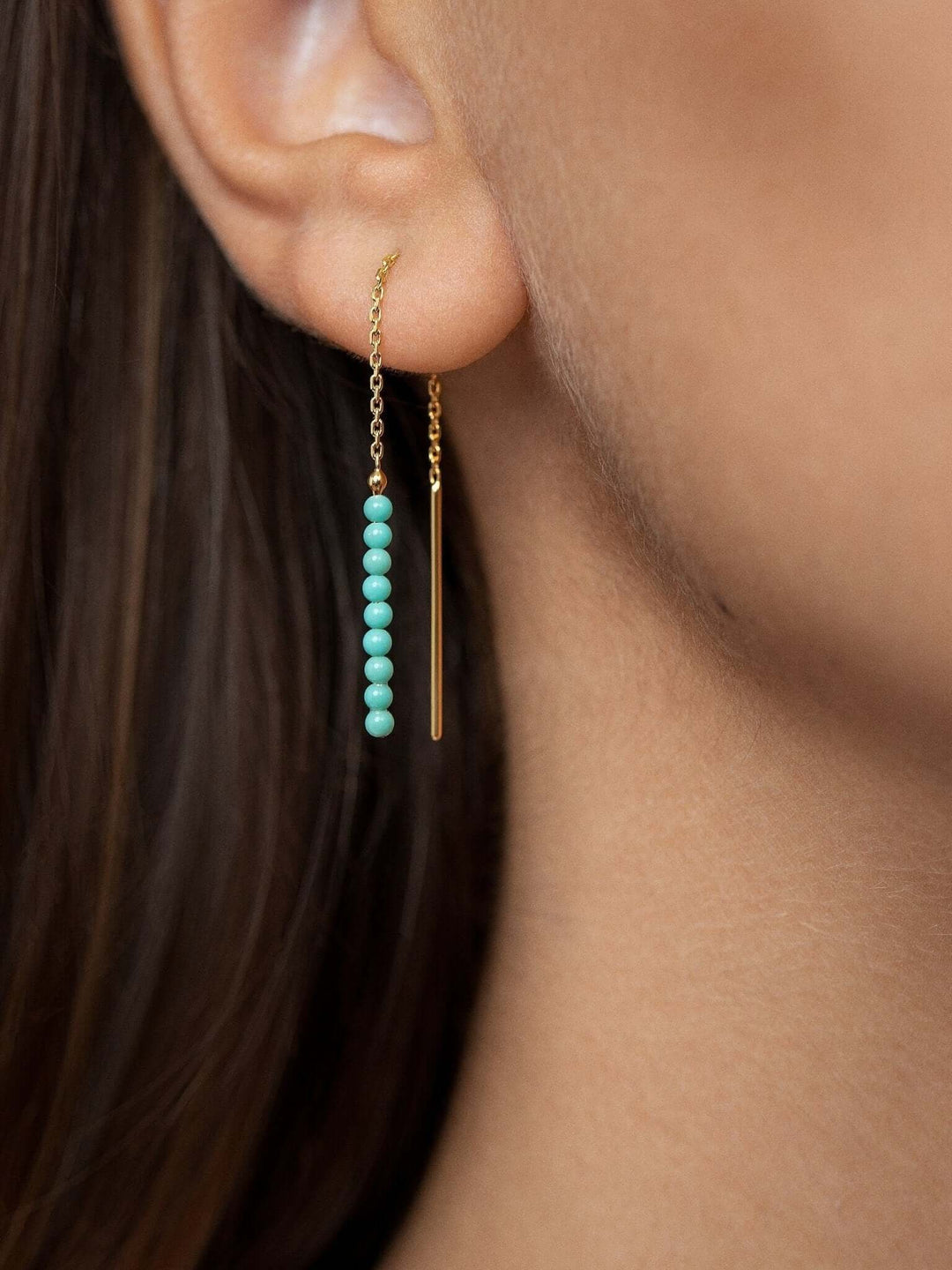 Turquoise threader earrings in 18K gold-plated chain, worn for an elegant look.