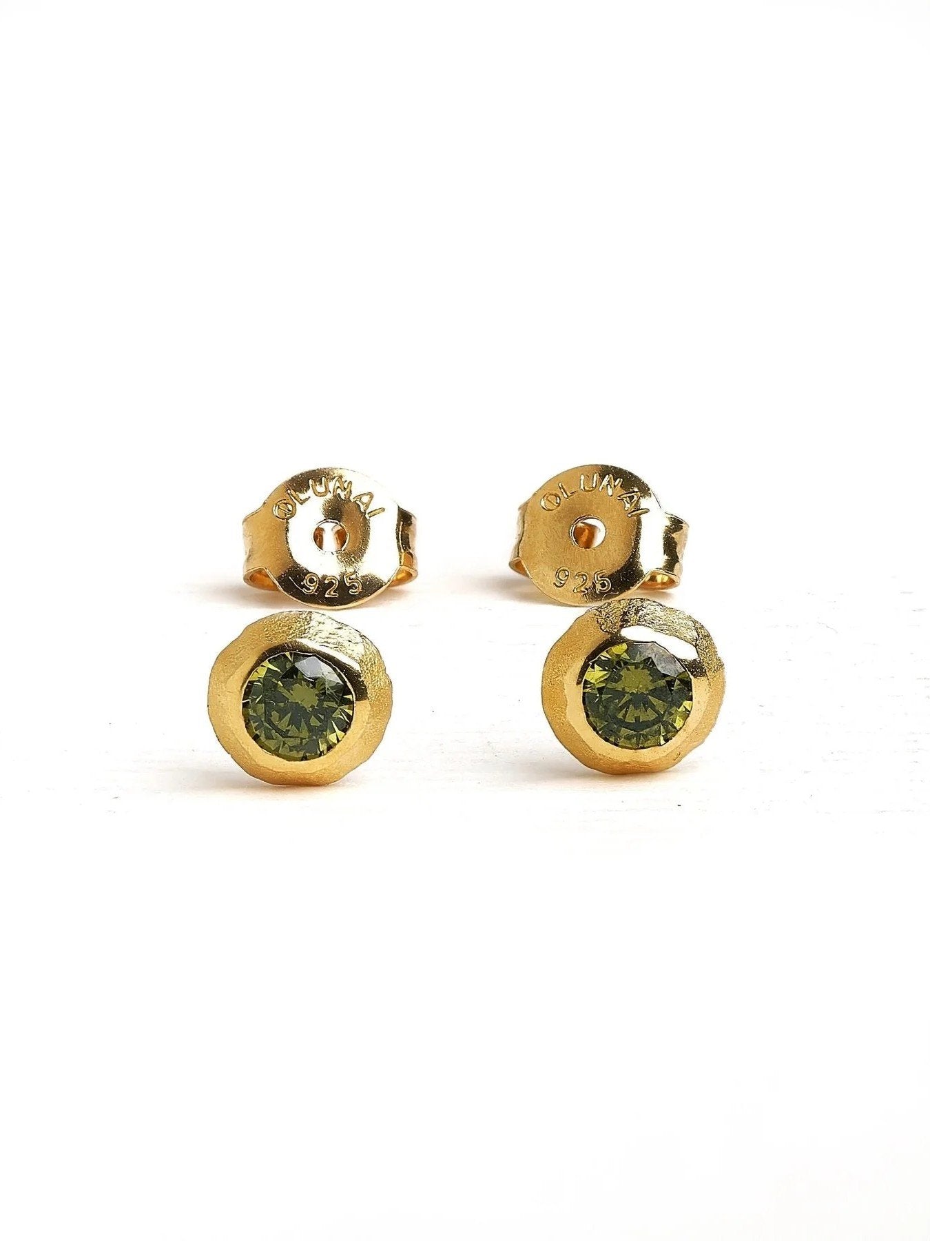 Gold stud earrings with green stone on a white background – minimalist design with a green gemstone in a gold bezel setting.