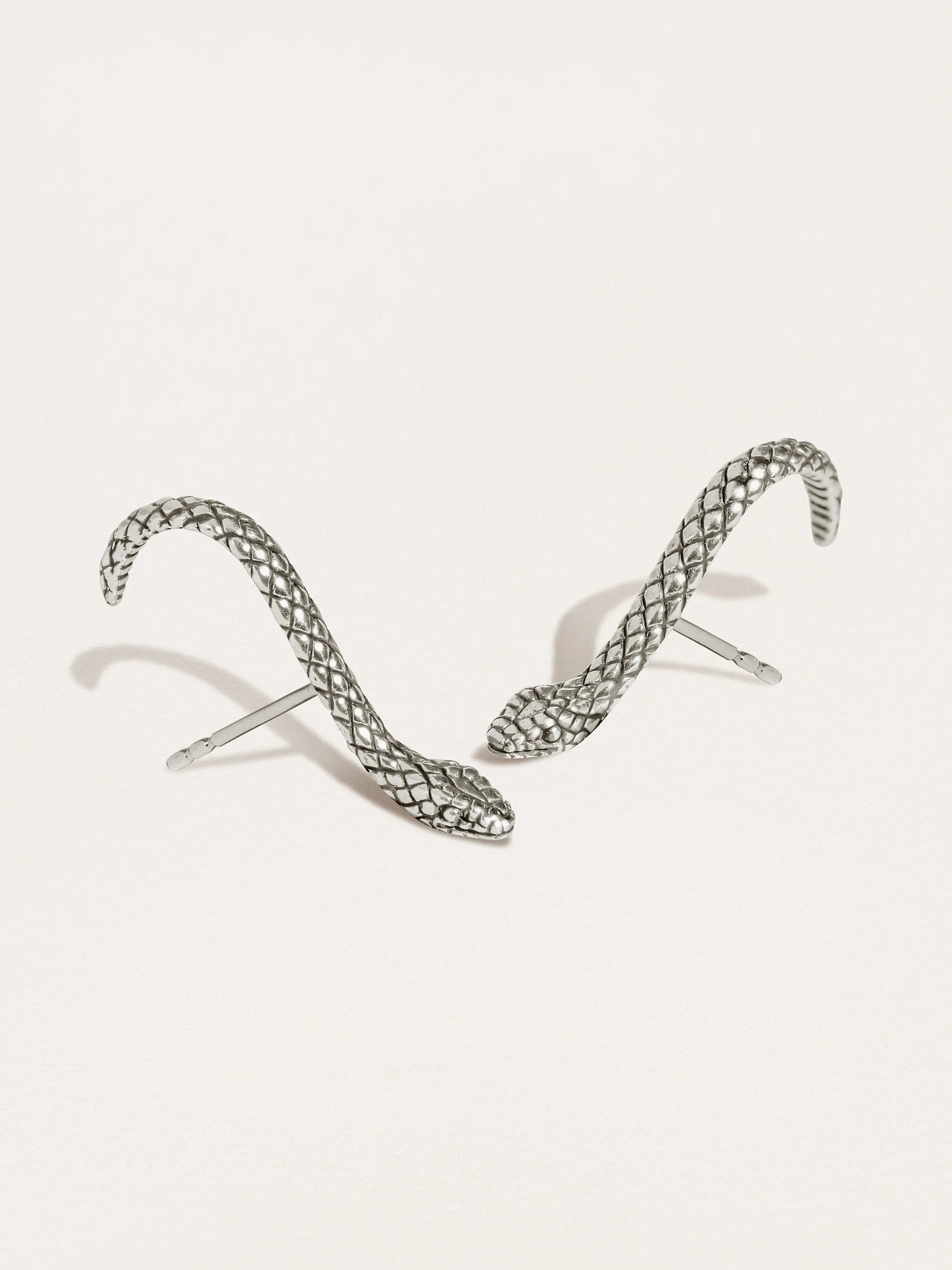 Snake Suspender Earrings in silver with intricate coiled design and dangling chains