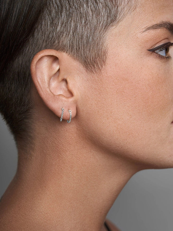 Gold chain threader earring on short-haired model, side profile view