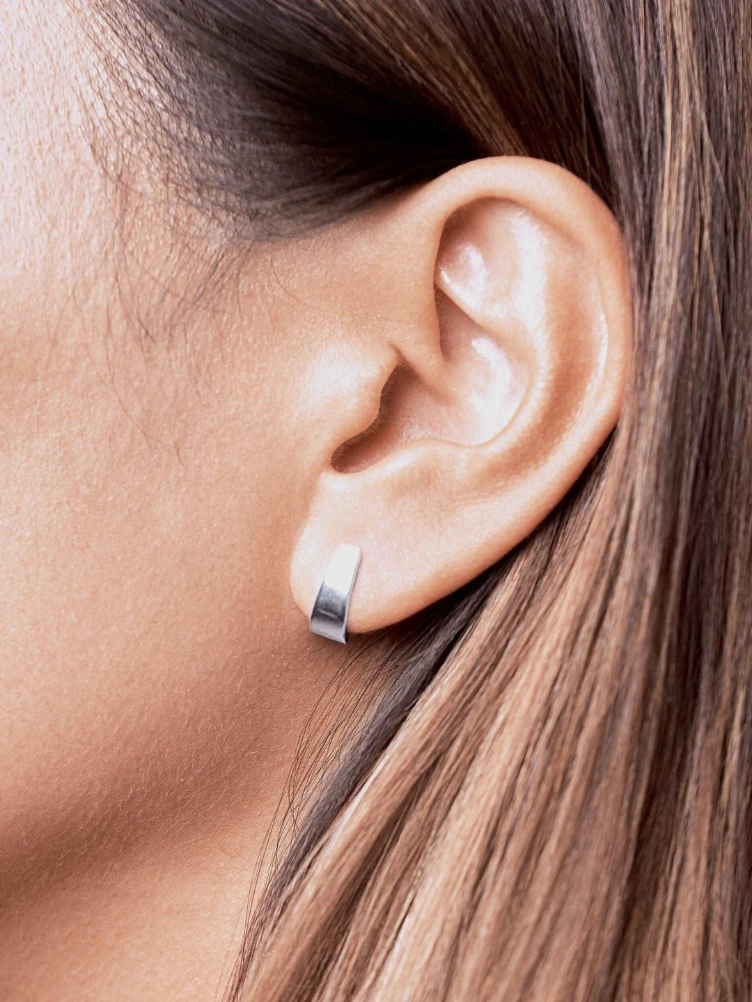 Terita stud earring in sterling silver worn — minimalist and polished look with sculptural curve.