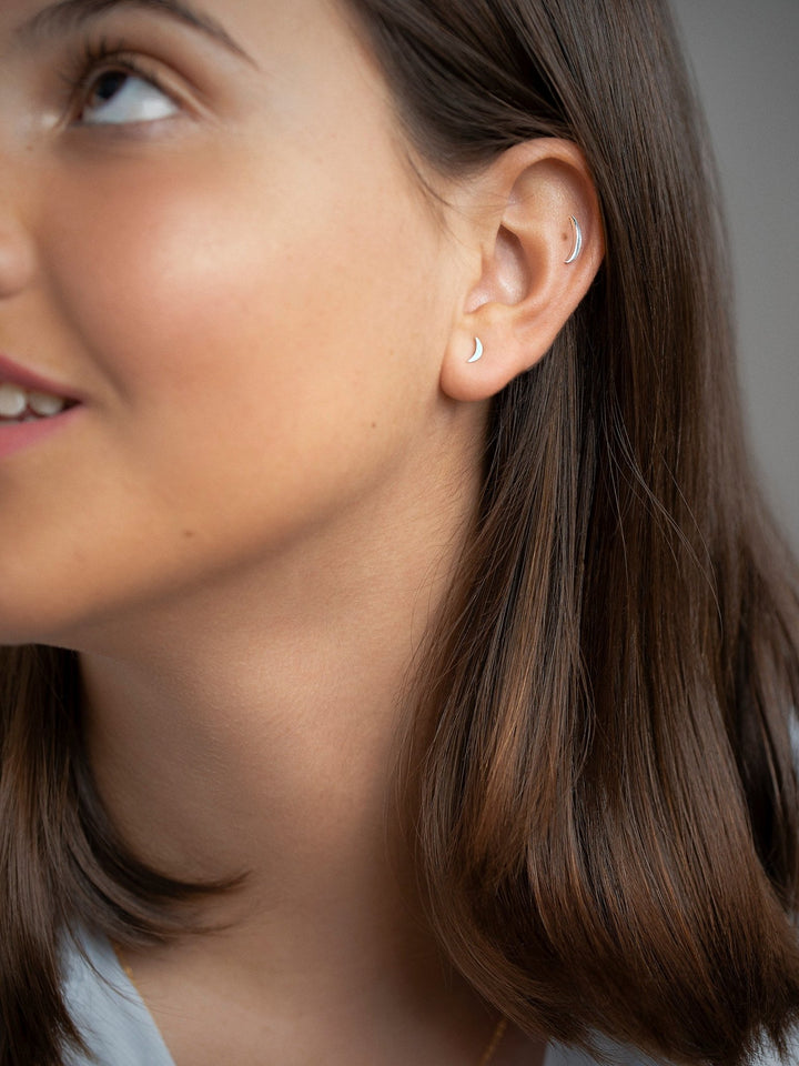 Woman wearing the Athina cartilage piercing, showing minimalist design on the helix.