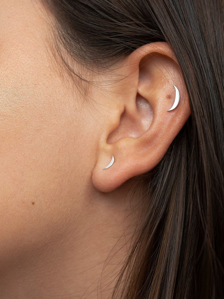 Profile view of model wearing a sterling silver cartilage piercing, highlighting its minimalist design on the ear.