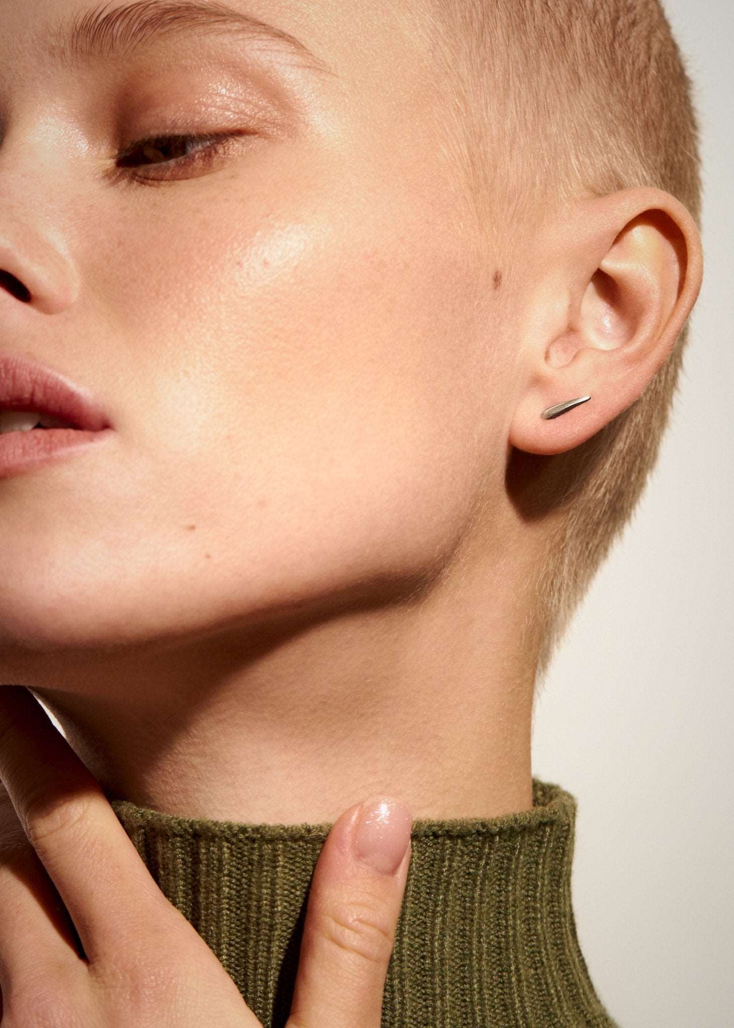 "Model wearing Aura Dainty Tusk Earrings in silver, front view"