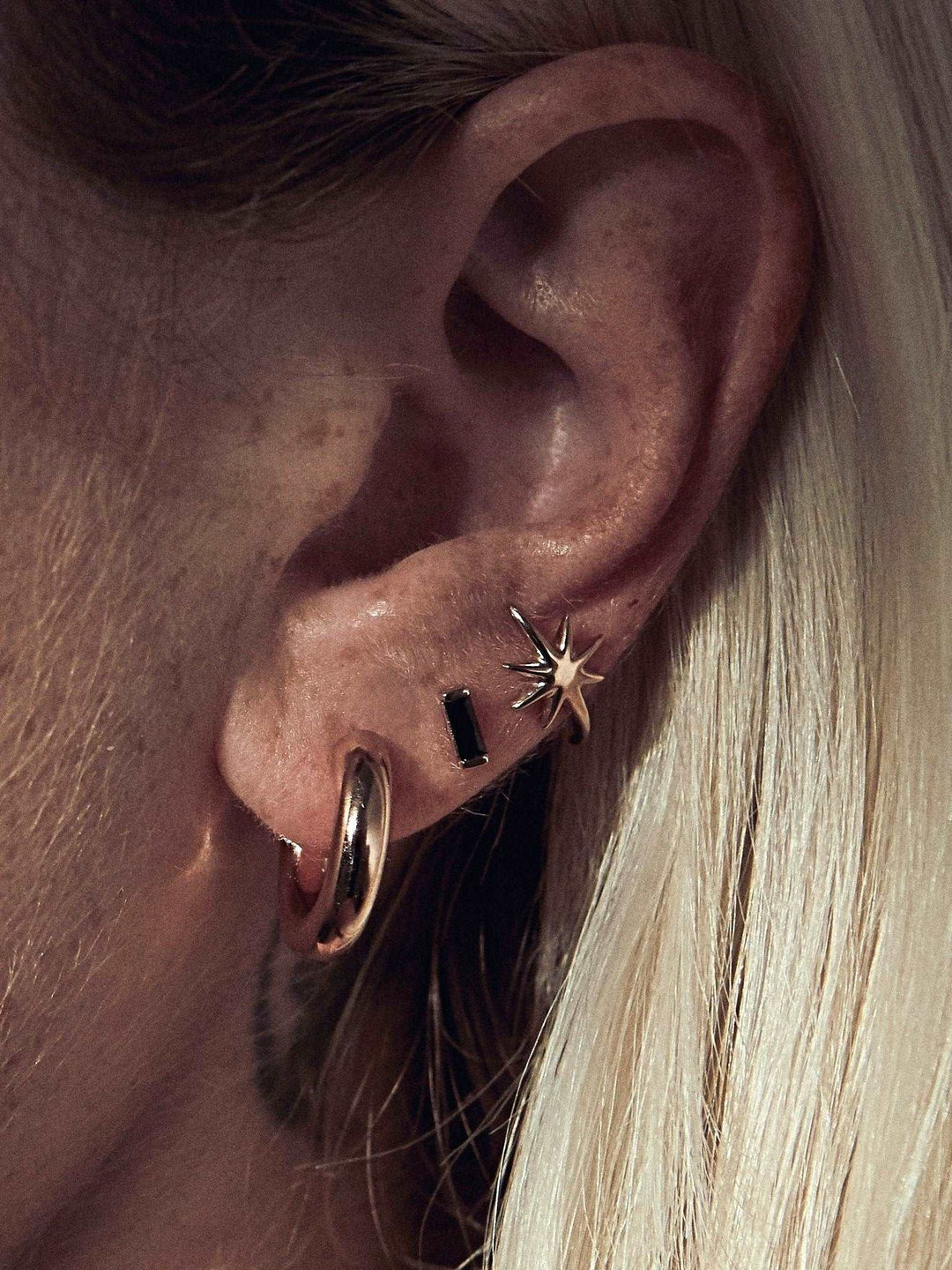 Birte open hoop earring in gold plated finish — radiant, lightweight, and bold on ear.