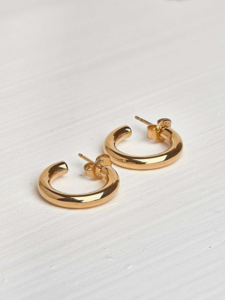 Birte open hoop earring in gold plated worn on ear — soft, timeless shine with minimalist styling.