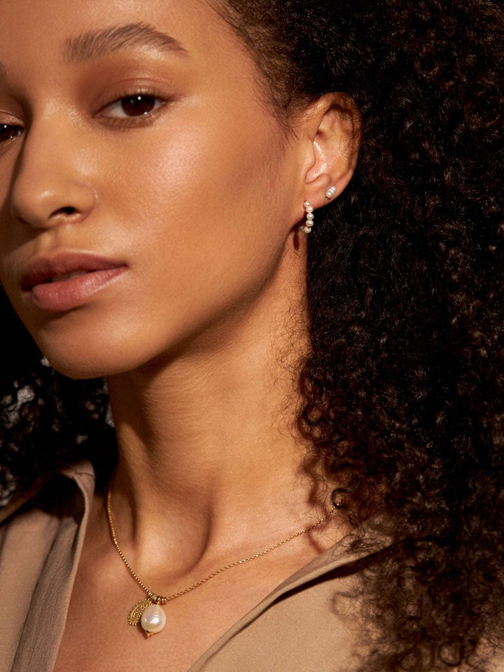 Model wearing Blanca elegant small pearl hoop earrings – 24K gold plated with pearl detail, chic and sophisticated designPearlsLunai Jewelry