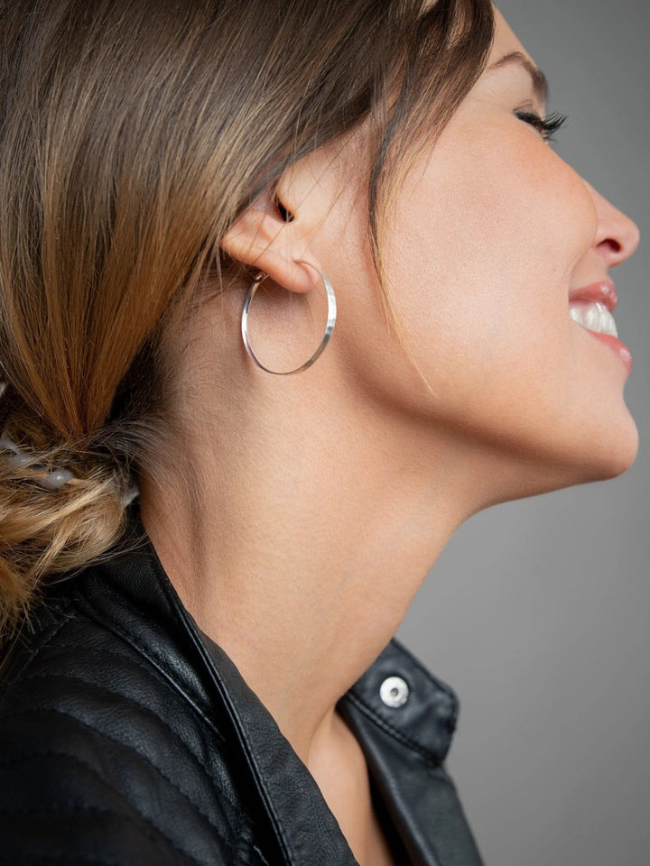 Model wearing 925 sterling silver matte hammered hoop earring – handmade and sustainable.