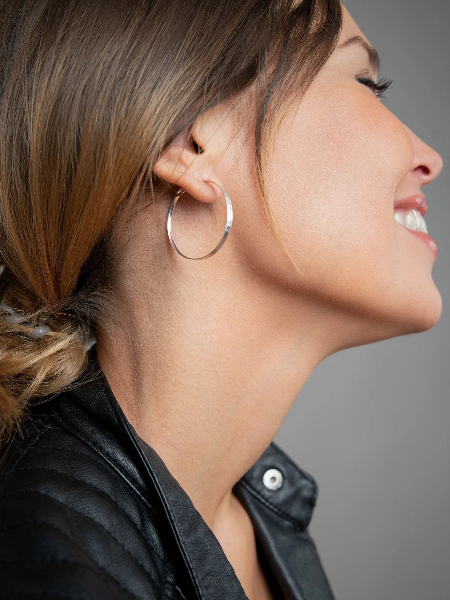 Model wearing 925 sterling silver matte hammered hoop earring – handmade and sustainable.