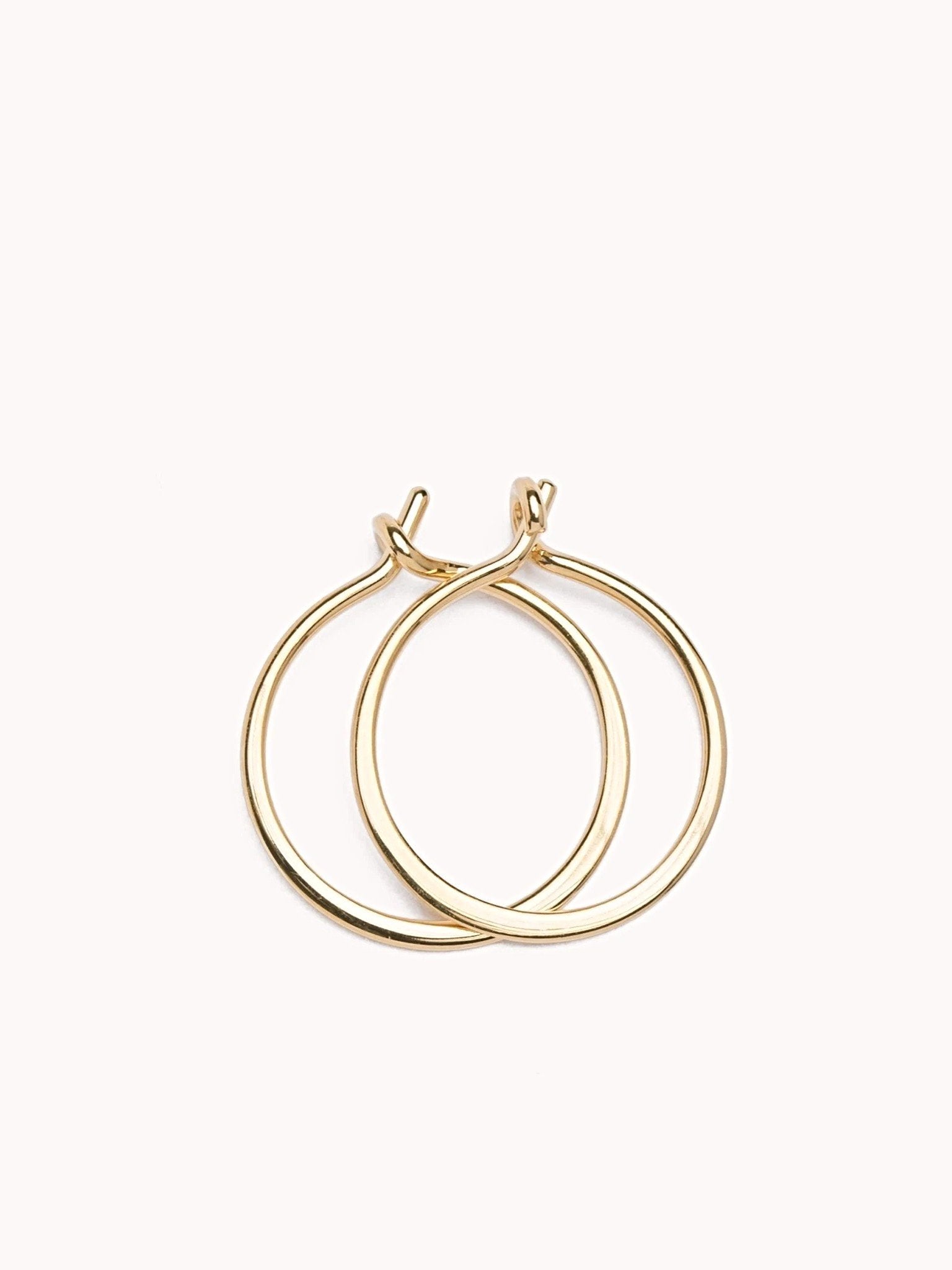 Double Rose gold hoop earrings, minimalist and elegant, on a soft pink background