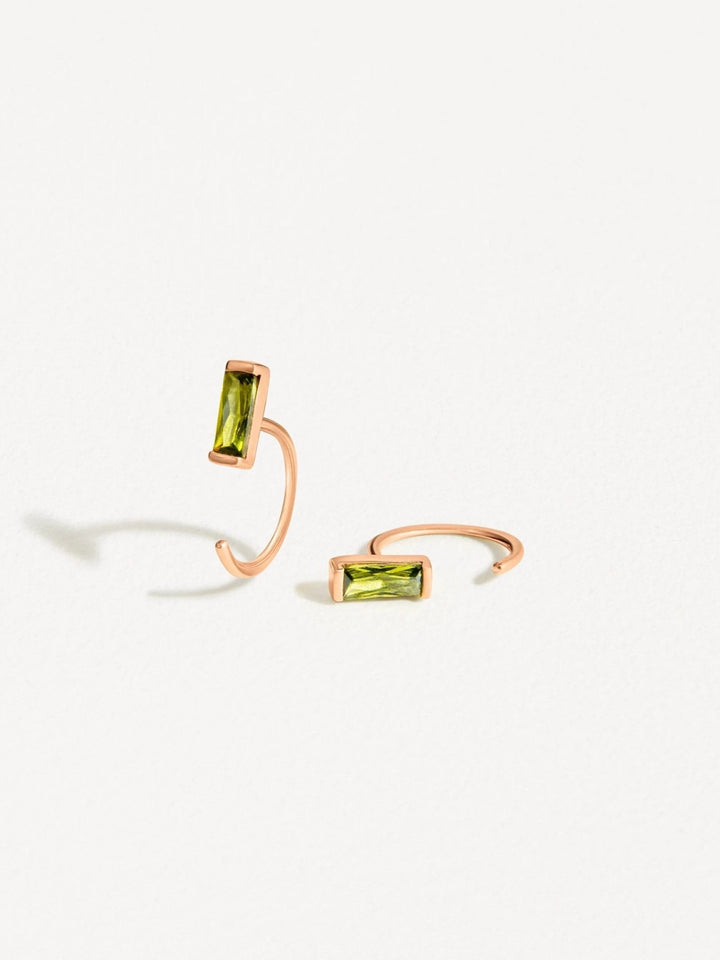 Minimalist peridot open hoop earrings in rose gold, featuring a sleek bar-set gemstone on a curved hoop.