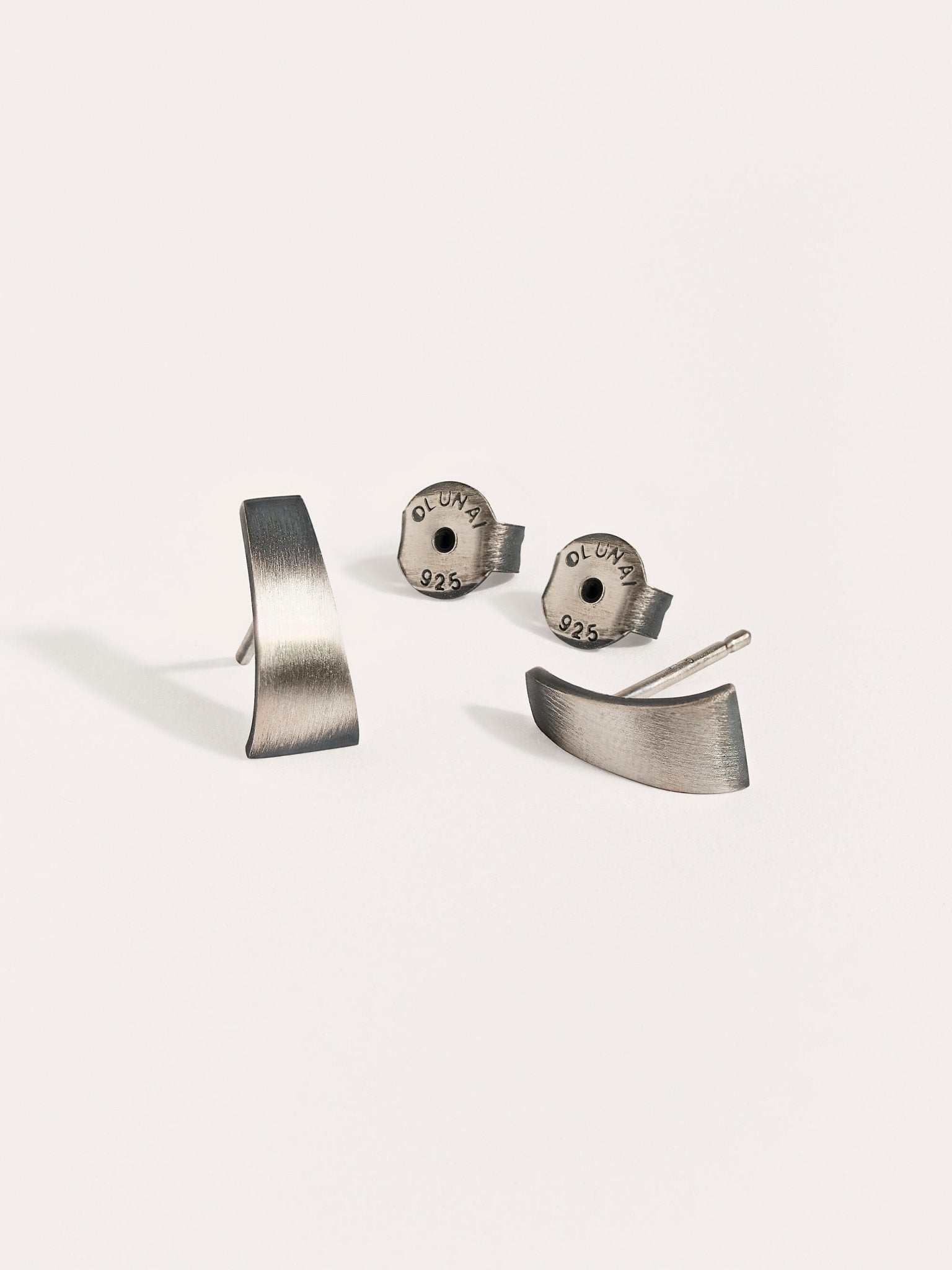 Terita stud earrings in oxidized silver with screw backs — matte finish and sculptural shape on white background.
