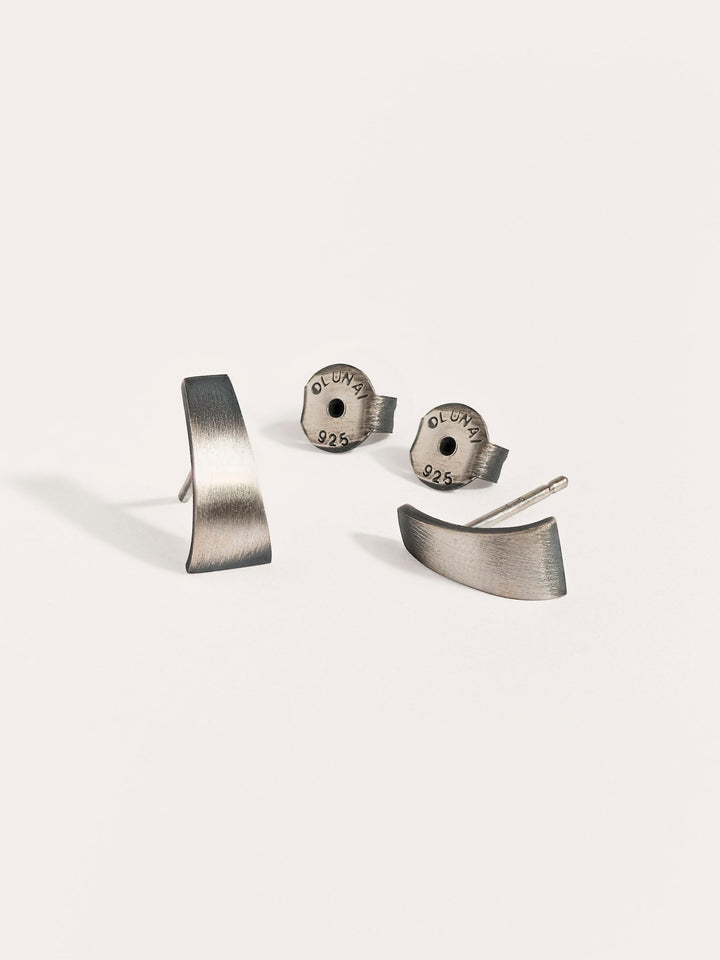 Terita stud earrings in oxidized silver with screw backs — matte finish and sculptural shape on white background.