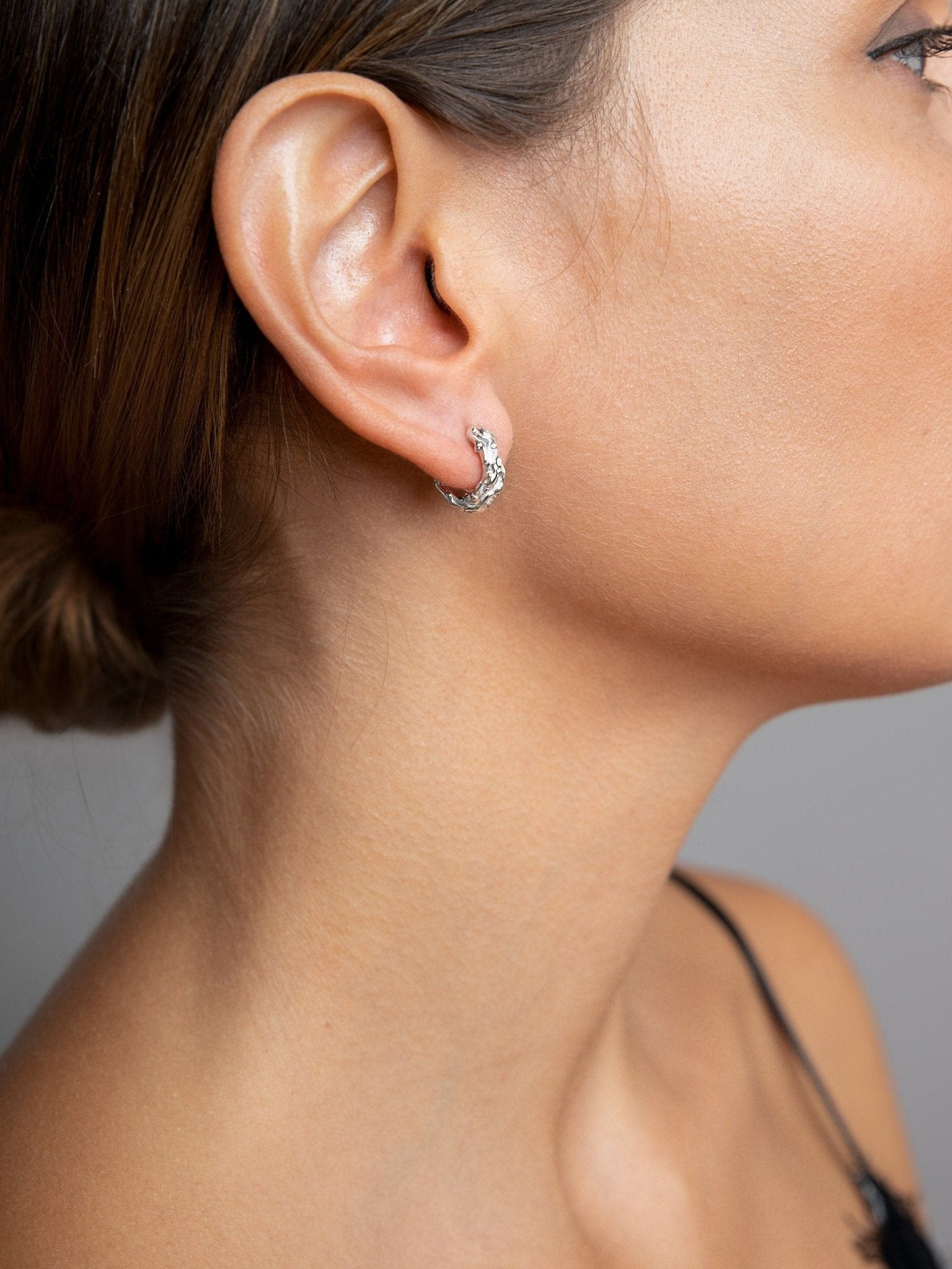 Model wearing Groessa Raw Texture Open Hoop Earrings in silver, ideal for everyday style.