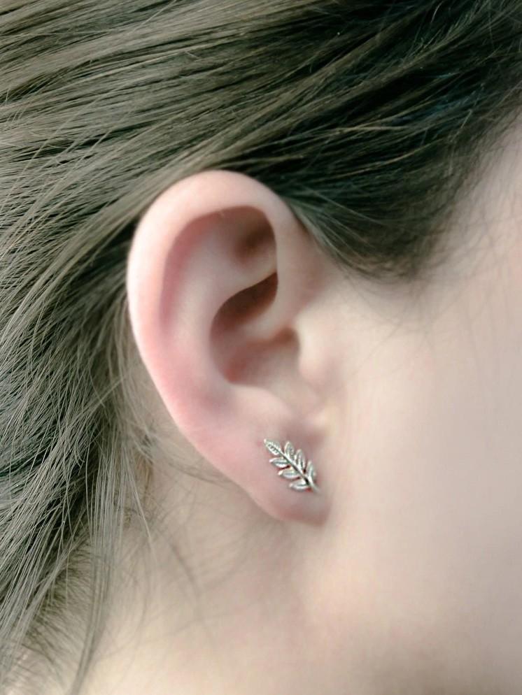 Gudrun silver leaf stud earring worn — subtle shine with organic form.
