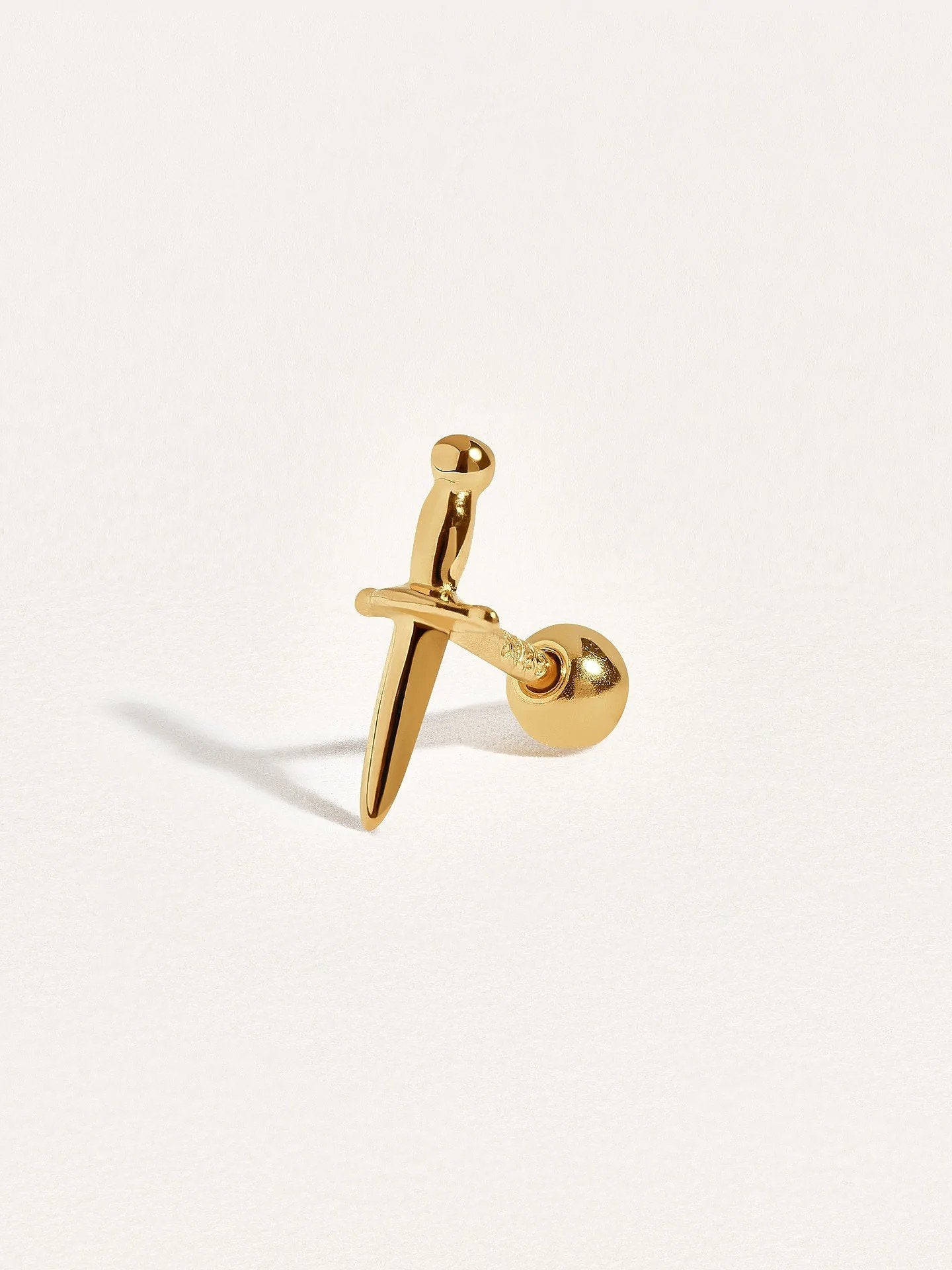 Single gold dagger cartilage stud with ball back, angled view showing secure screw design and delicate shine.