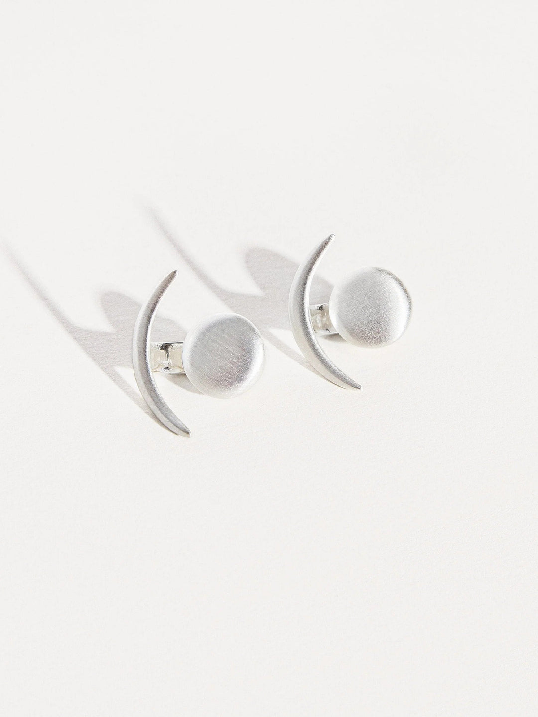 Sterling silver ear jackets, photographed on a white background with soft lighting.