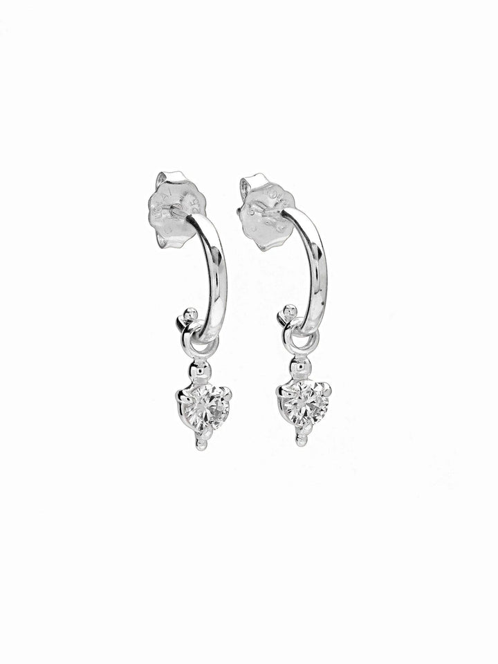 Silver hoop earrings with heart-shaped zirconia, side view