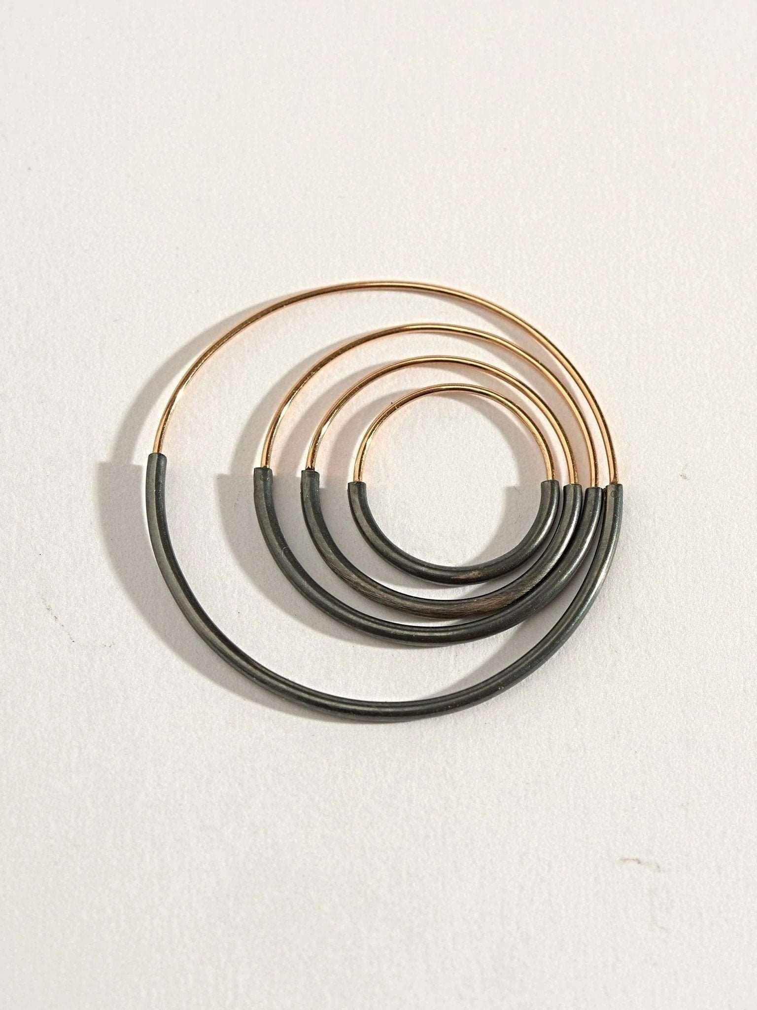 Set of Kim hoop earrings in gold filled and oxidized silver — five minimalist sizes on white background.