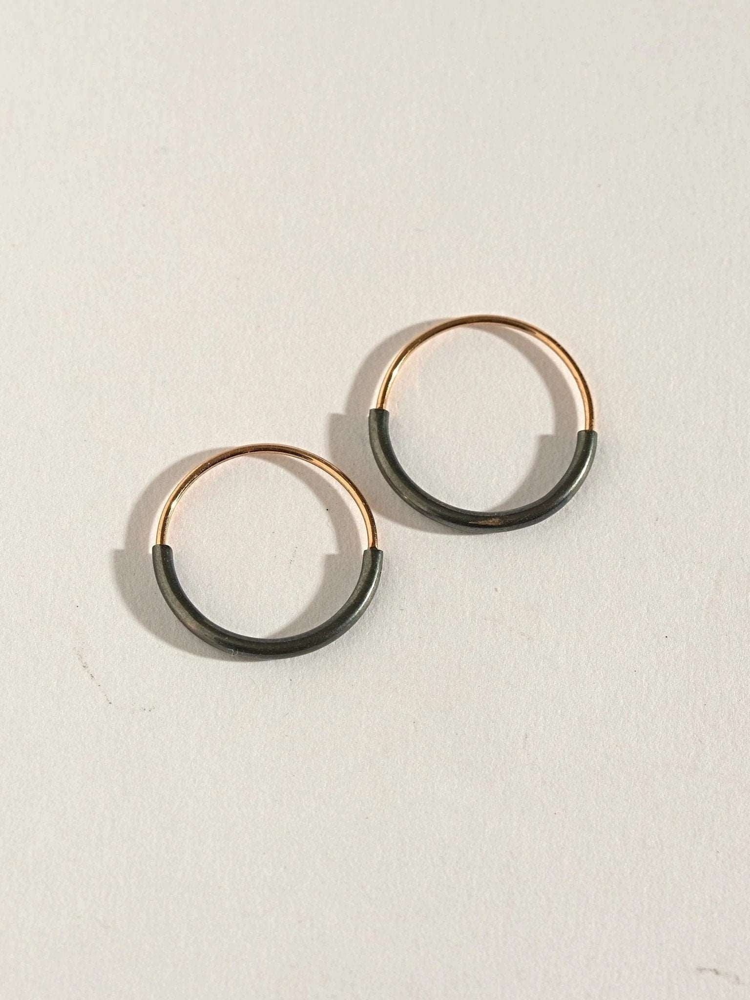 Pair of Kim small hoop earrings in gold filled and oxidized silver — clean contrast design.