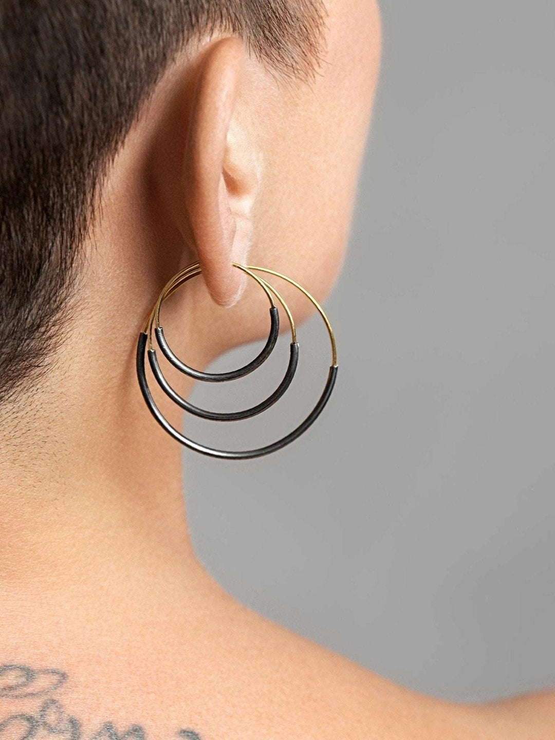 ack view of Kim hoop earring in oxidized silver — lightweight and artistic silhouette.