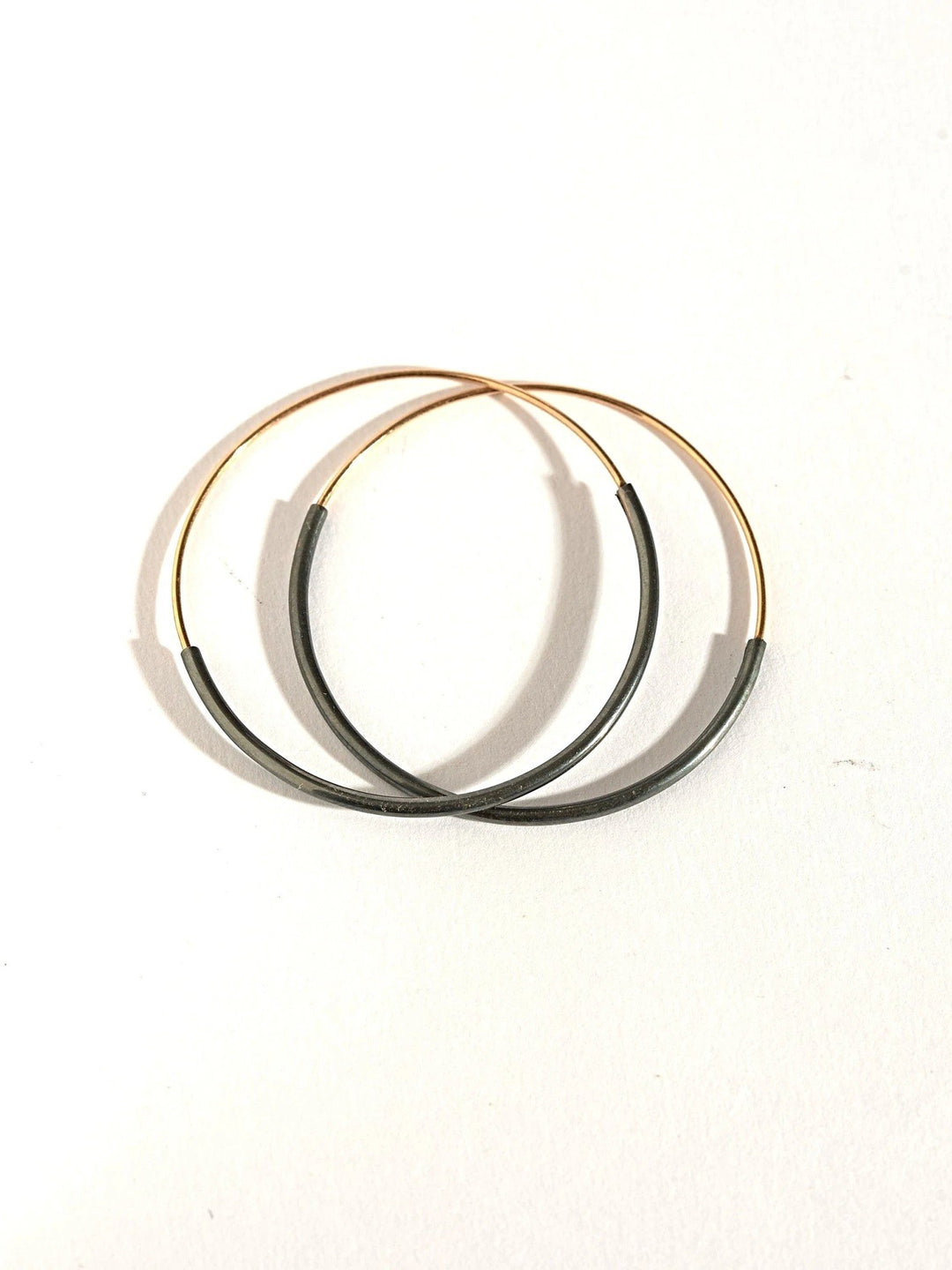 Stacked Kim hoop earrings in gold filled and oxidized silver — layered contrast in clean composition.
