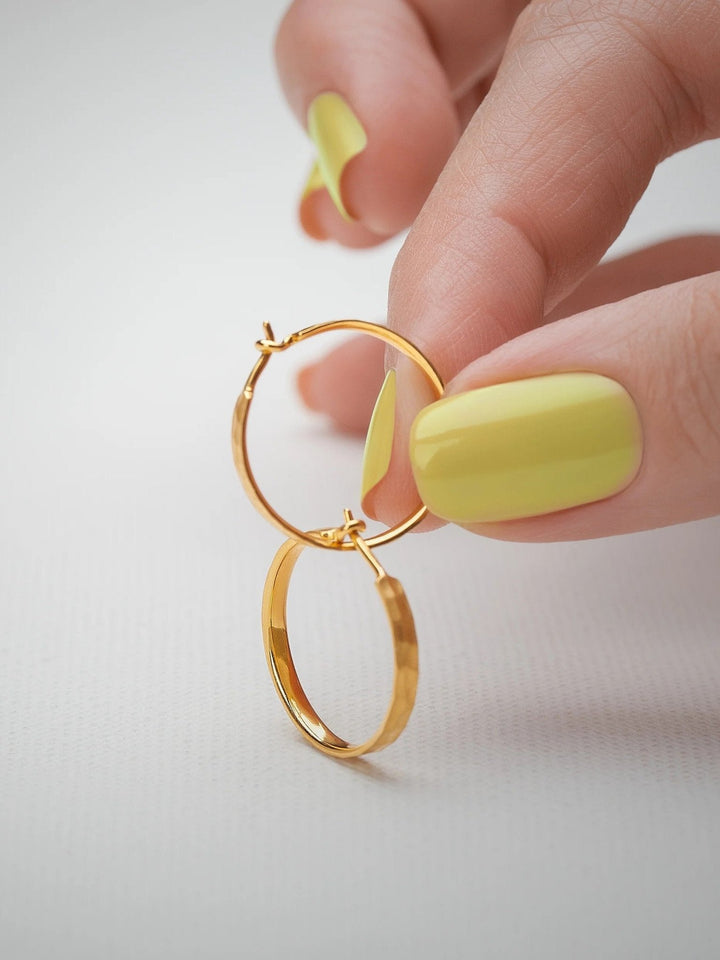 Hand holding medium hammered 24K gold matte hoop earrings – highlighting texture and craftsmanship