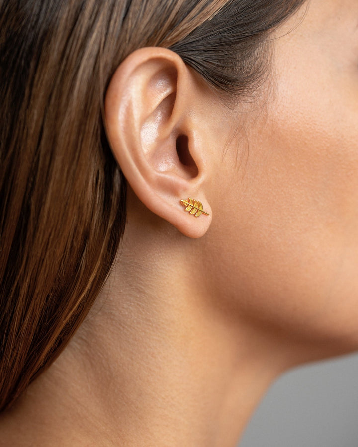 Gudrun leaf earrings in gold worn — minimalist and nature-inspired elegance.