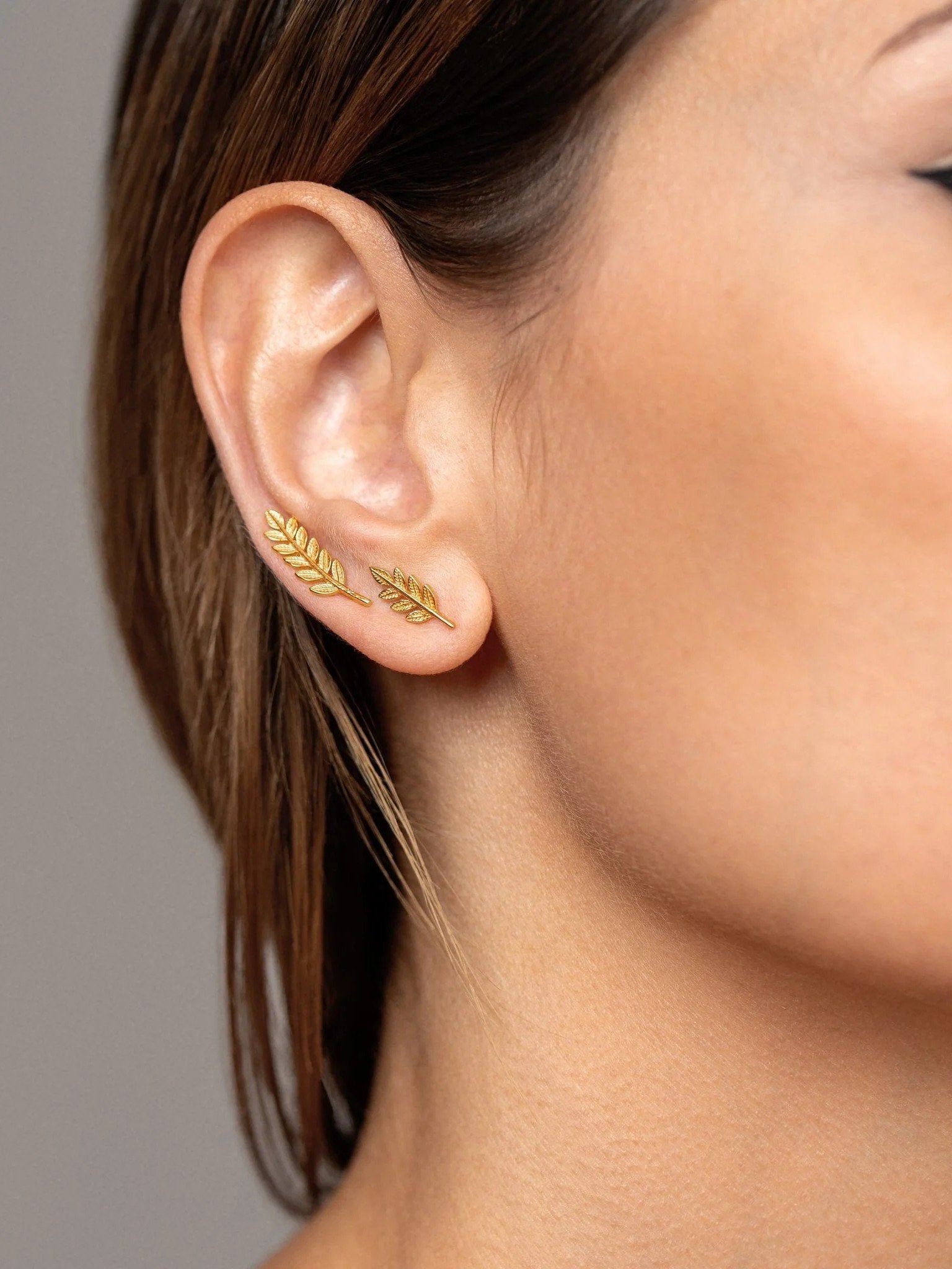 Close-up of Gudrun gold earrings styled — graceful and sculptural accent.