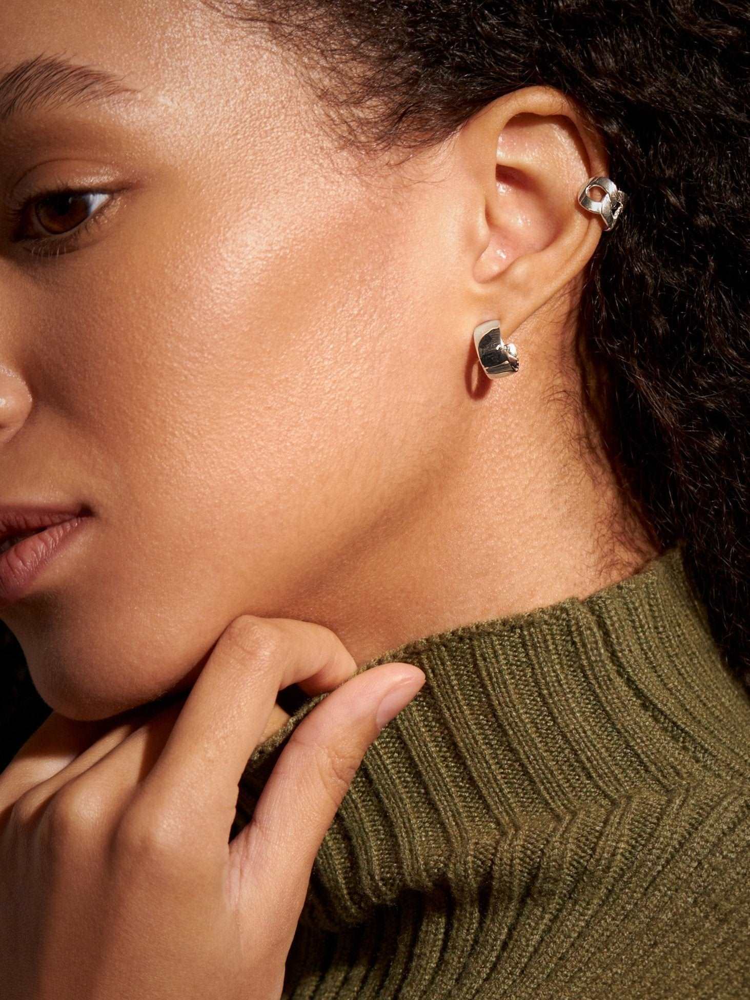 Sterling silver hoop earrings styled with cozy green sweater.