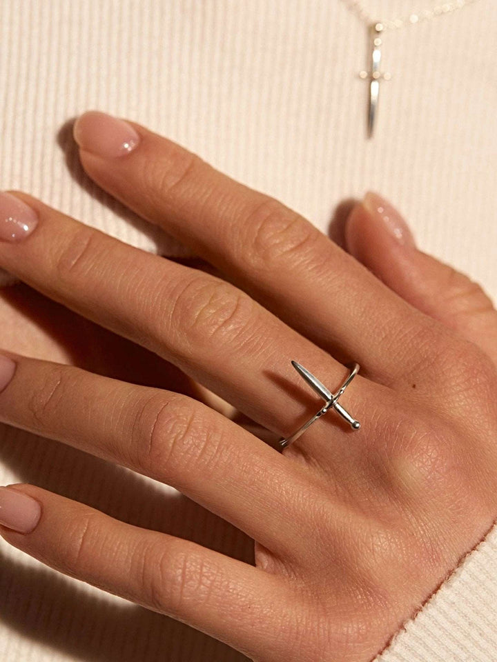 Sterling silver dagger ring worn on hand with neutral tones, elegant and subtle.