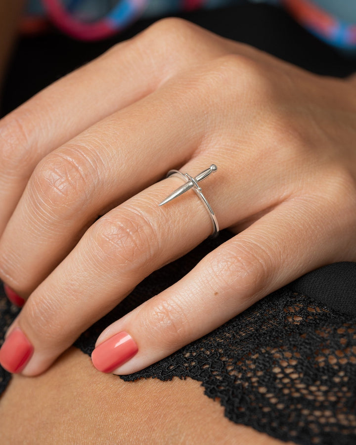 Silver dagger ring styled on hand with red nails, evoking a modern renaissance vibe.