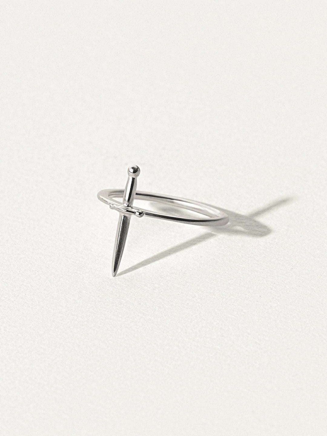 Minimalist dagger ring in 925 sterling silver, photographed on soft light background.