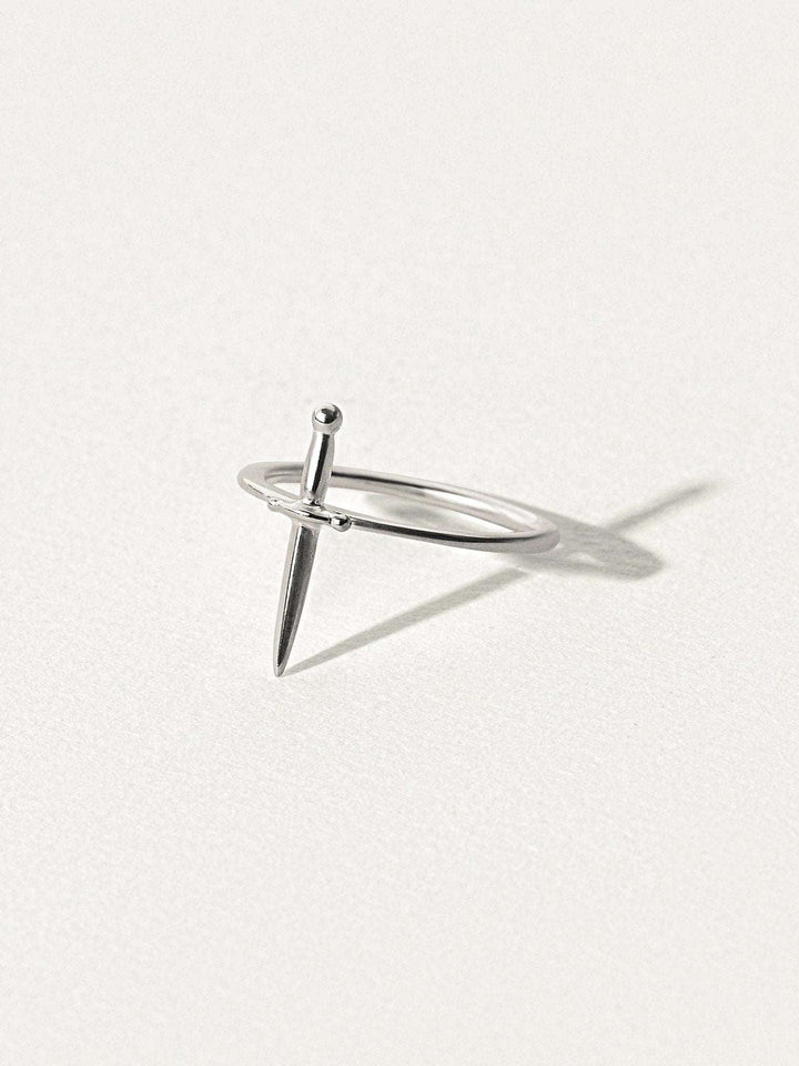 Minimalist dagger ring in 925 sterling silver, photographed on soft light background.