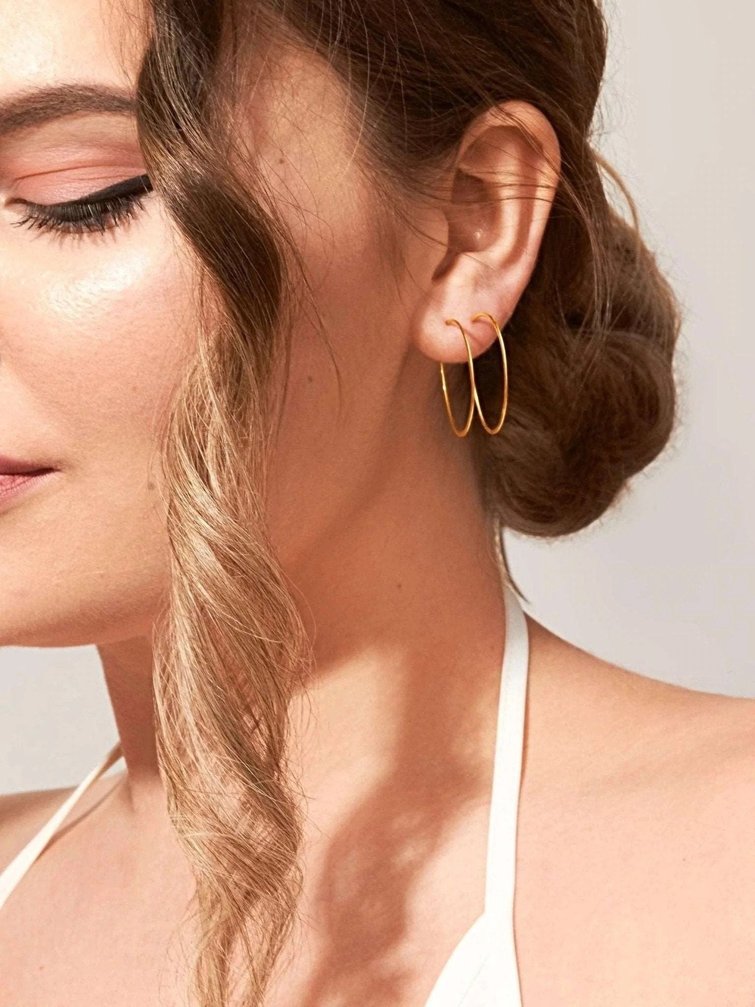 14K gold-filled second-hole hoop earrings worn by model – delicate and minimalist style.