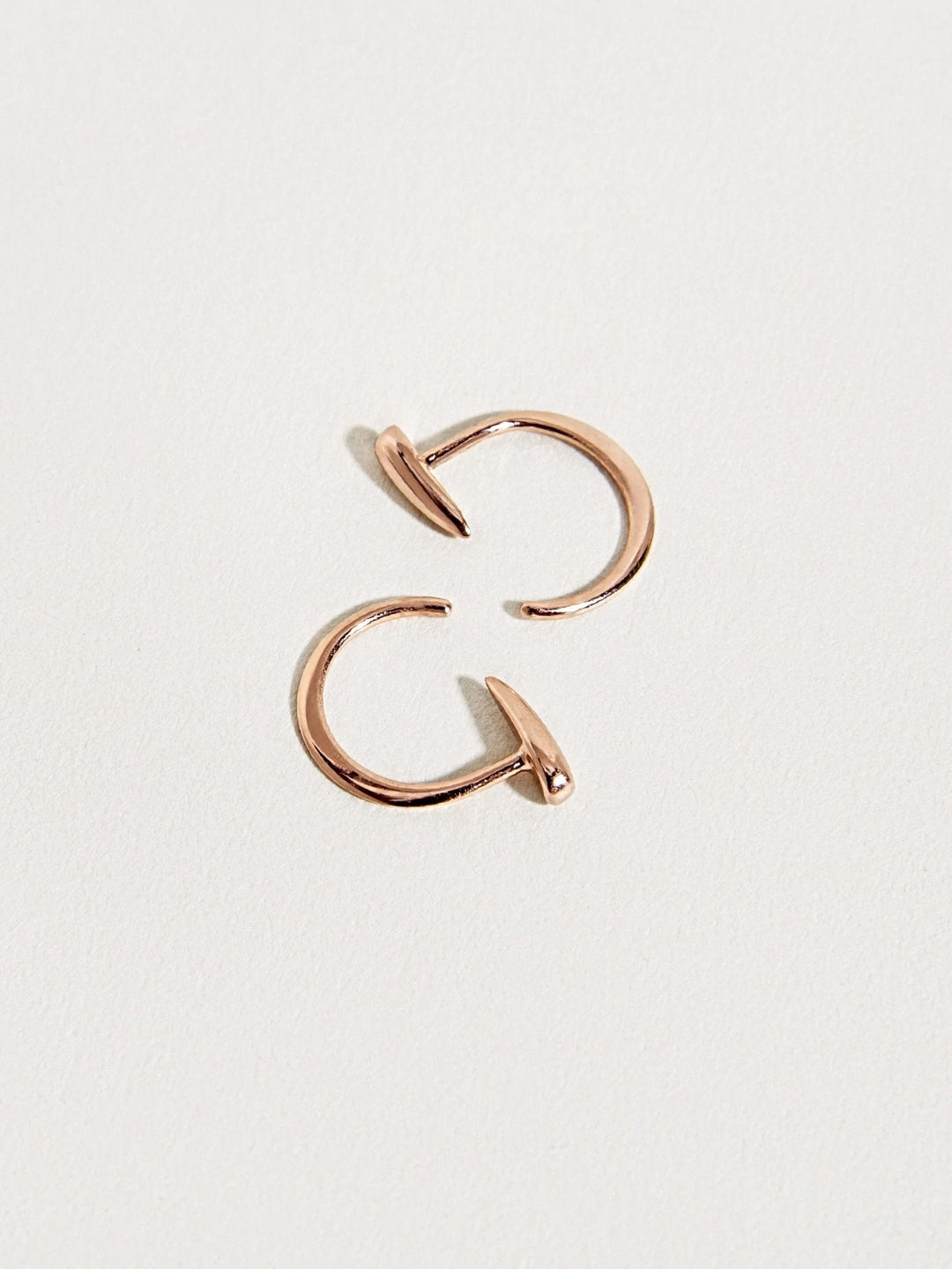 Luppa gold hoop earrings with curved open design — tusk-inspired silhouette.