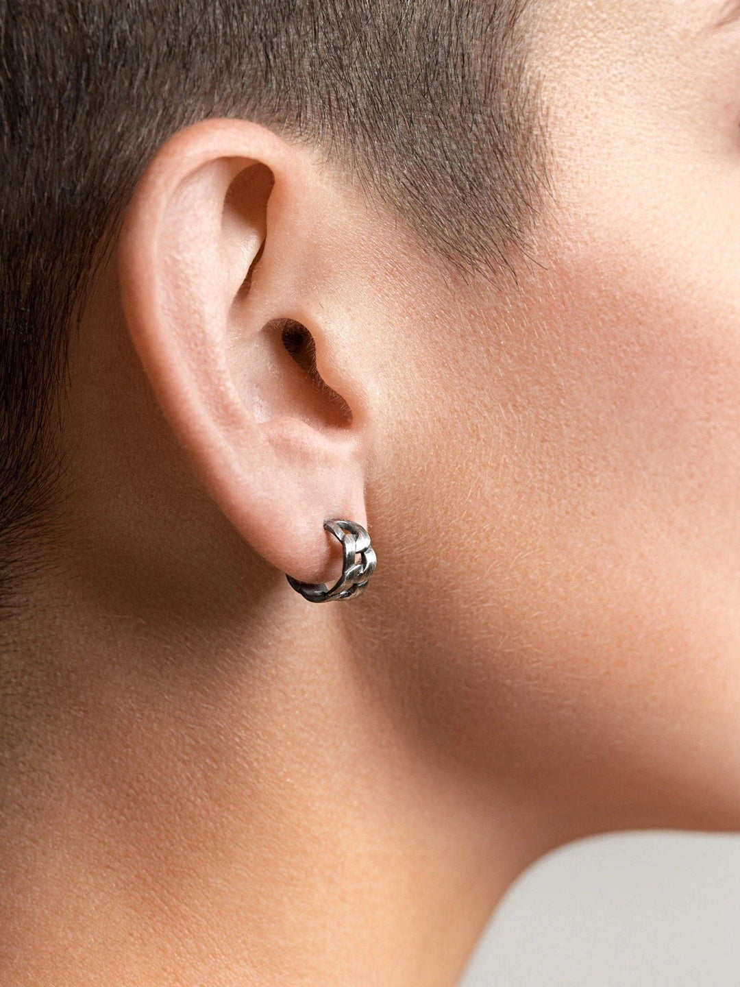 Rear angle of Meel Gold Hoop Earrings hugging the earlobe, highlighting their bold curve and secure screw back.