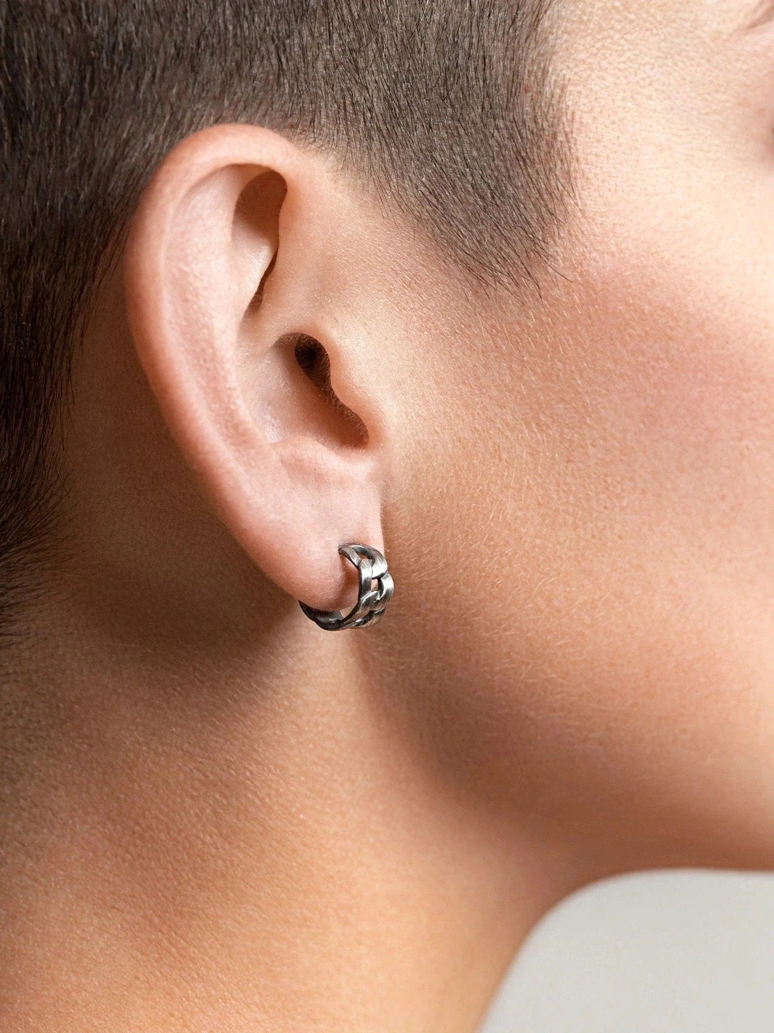 Rear angle of Meel Gold Hoop Earrings hugging the earlobe, highlighting their bold curve and secure screw back.