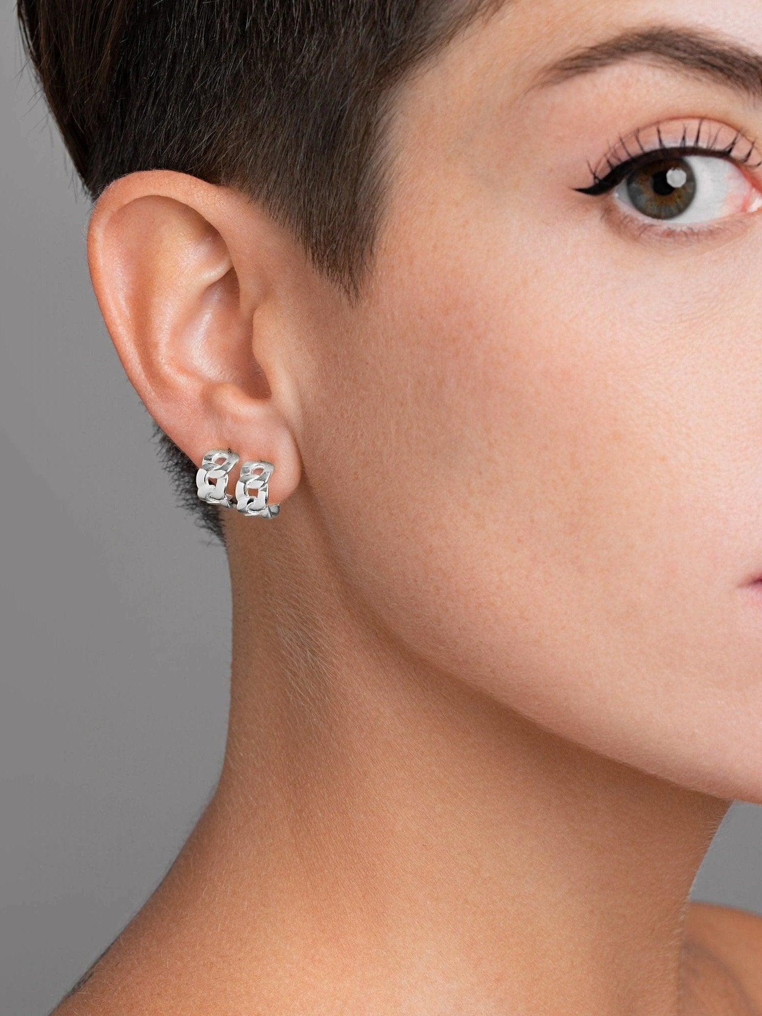 Semi-frontal close-up of Meel Gold Hoop Earrings on short hair, emphasizing the bold 24K gold plating and modern silhouette.