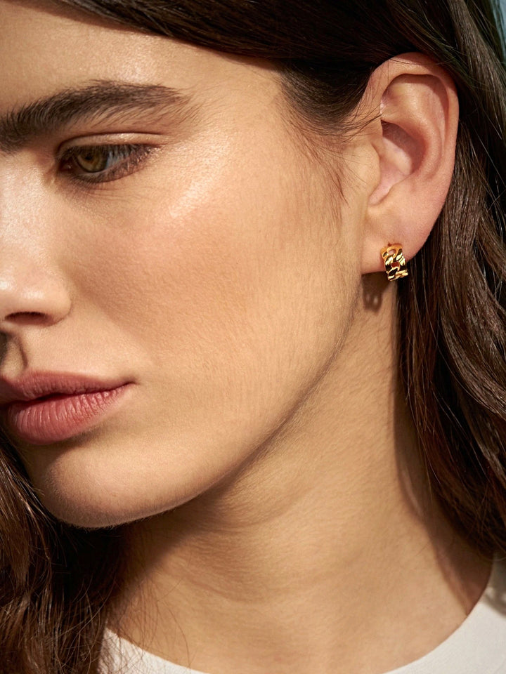 Woman wearing Meel Gold Hoop Earrings with flowing hair, showing the chunky 24K gold chain link design styled with elegance.