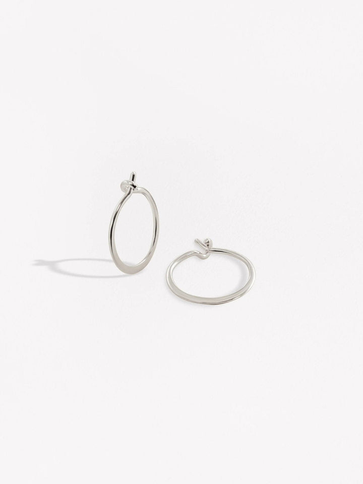 Silver hoop earrings with a sleek open design on a white background.