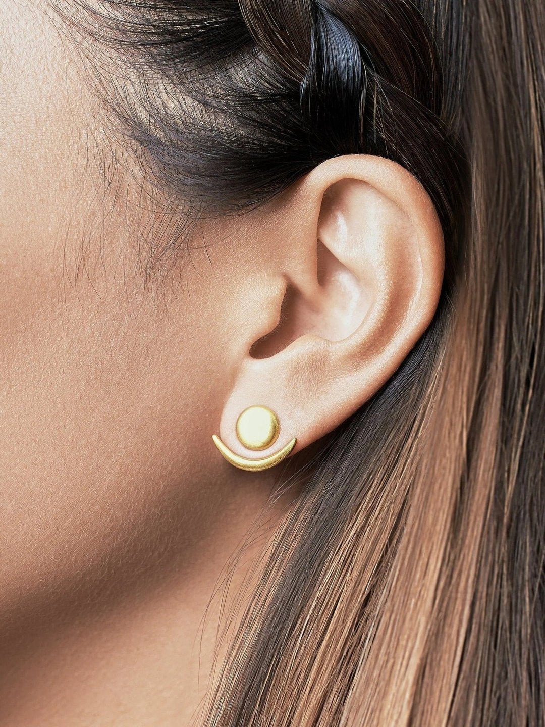 Gold matte ear jackets with a versatile design, close-up on a model with tied-back hair.