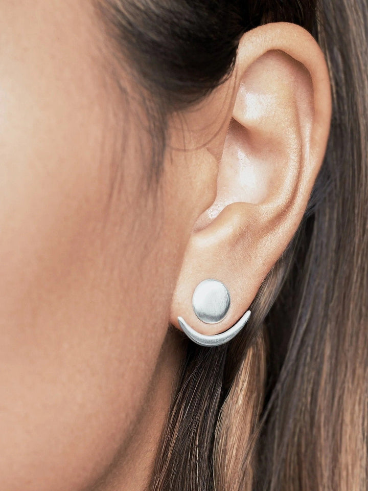 Sterling silver matte ear jackets, side view on a model with warm lighting.