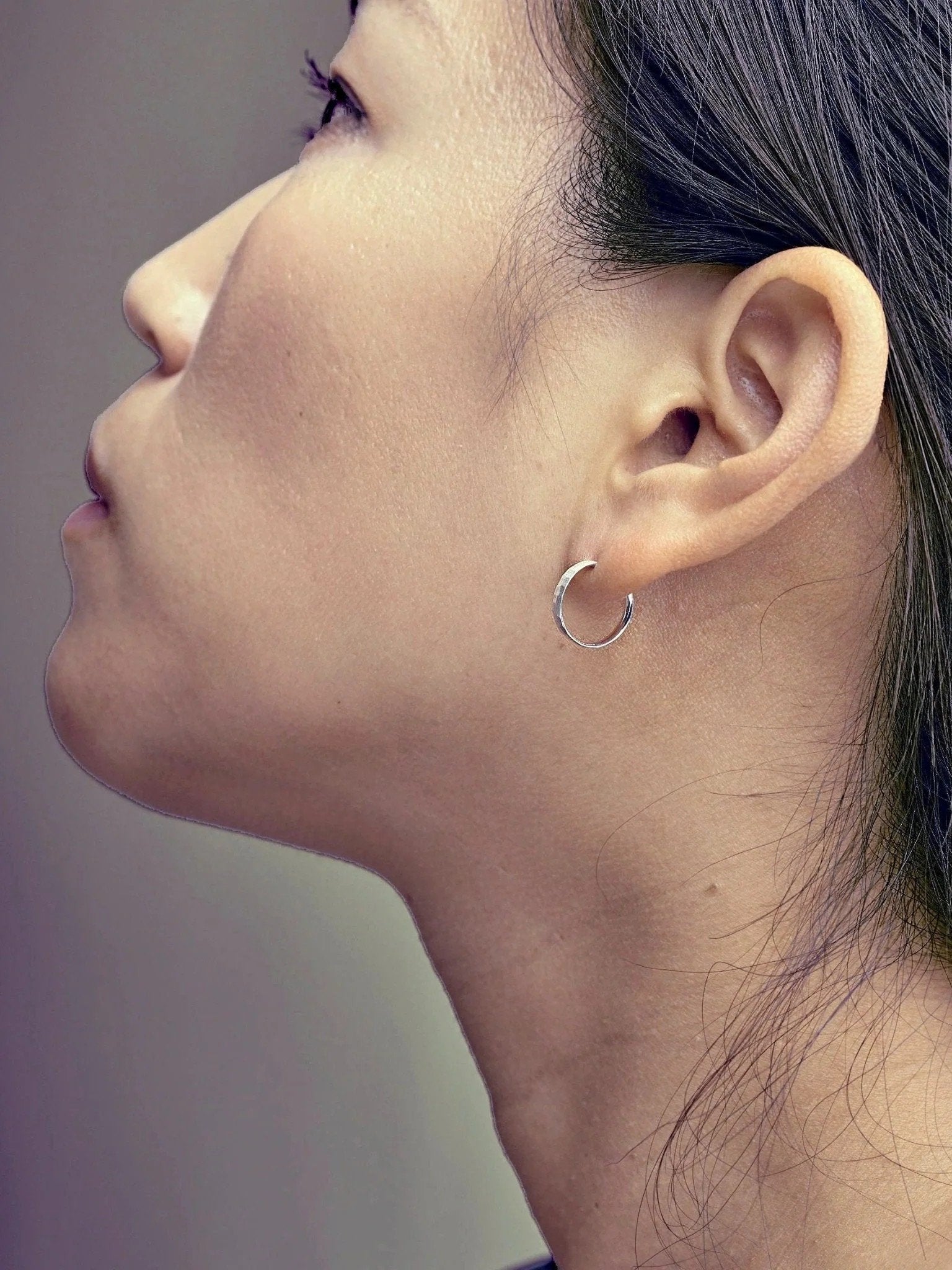 Nanna huggie earring in matte sterling silver — worn on upper lobe, clean and modern look.