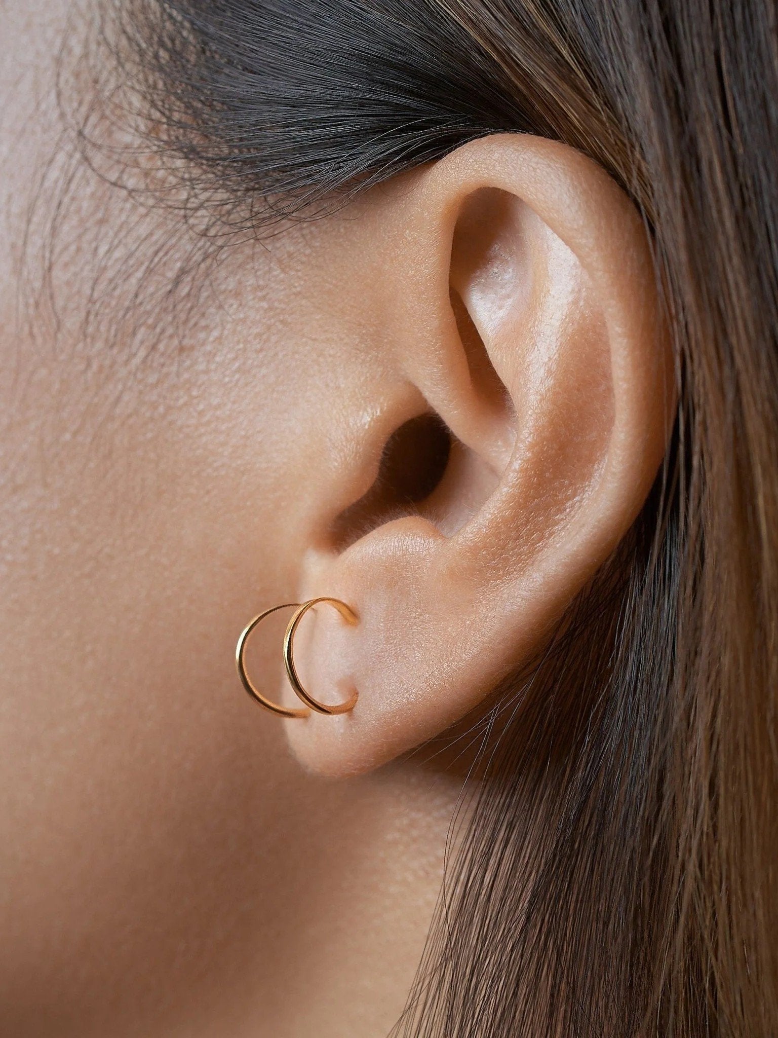 Noe gold hammered hoop earring worn on ear — elegant handcrafted hoop with polished finish.
